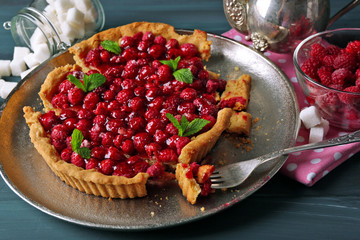 Piece of tart with raspberries on tray, close-up
