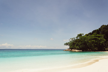 Obraz na płótnie Canvas blue sky with sea and beach - soft focus with film filter