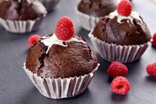 Delicious chocolate cupcakes with berries on table close up