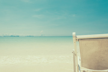 beach chair on beach with blue sky - soft focus with film filter