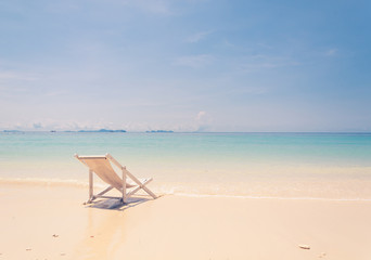 beach chair on beach with blue sky - soft focus with film filter
