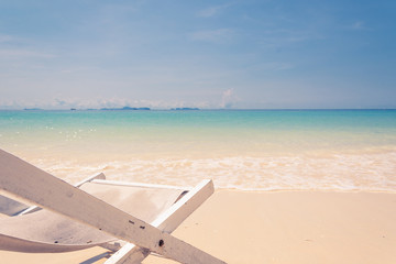 beach chair on beach with blue sky - soft focus with film filter