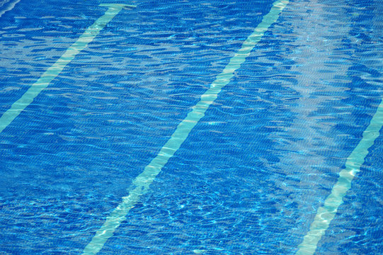 Clear blue water ripples in a swimming pool. Empty copy space for editor's text