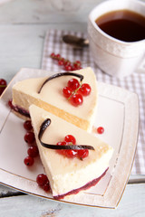 Tasty cheesecake with berries and cup of tea on table close up
