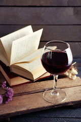 Beautiful composition with glass of wine with old books on table close up