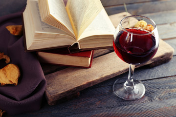 Beautiful composition with glass of wine with old books on table close up