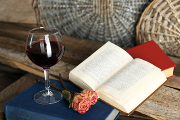 Beautiful composition with glass of wine with old books on table close up