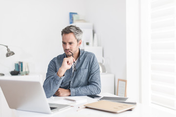 Portrait of a nice smiling grey hair man with beard holding his