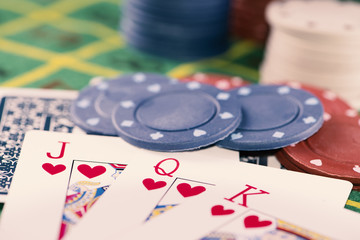 Cards and poker chips on green carpet