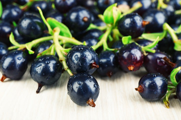 Pile of wet black currants on wooden table, closeup