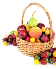 Heap of fresh fruits and berries in basket isolated on white