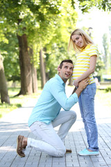 Young pregnant woman with husband outdoors