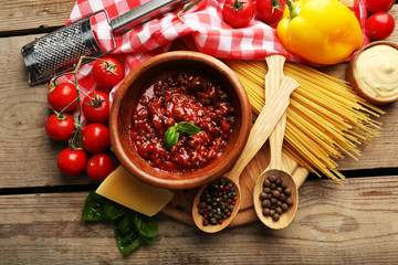 Pasta spaghetti with tomatoes, sauce bolognese, cheese and basil on rustic wooden  background