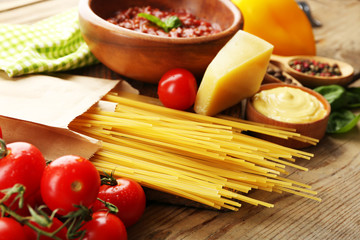 Pasta spaghetti with tomatoes, sauce bolognese, cheese and basil on rustic wooden  background