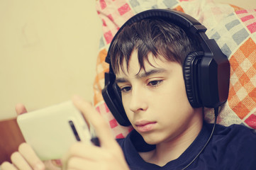 Teen using a smart phone to listen music with headphones