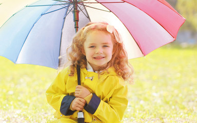 Portrait of little girl child with colorful umbrella in sunny au