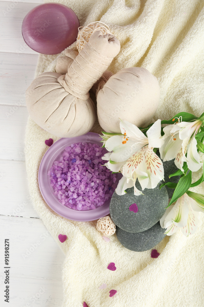 Poster massage bags with spa treatment and flowers on wooden table background