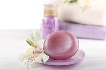 Spa treatment and flowers on wooden table, on light background