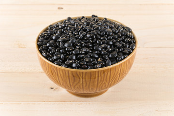 Fototapeta na wymiar black beans on wood background