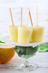 Melon ice lolly on table on light blurred background