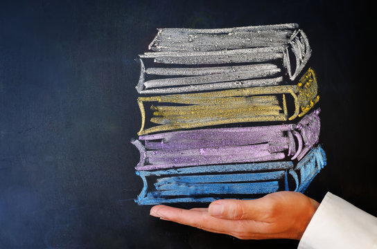 Man's hand holding a stack of books drawn with chalk