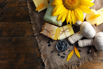 Spa treatments and sunflower on wooden background