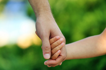 Father and daughter hands outdoors
