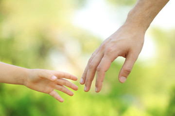 Father and daughter hands outdoors