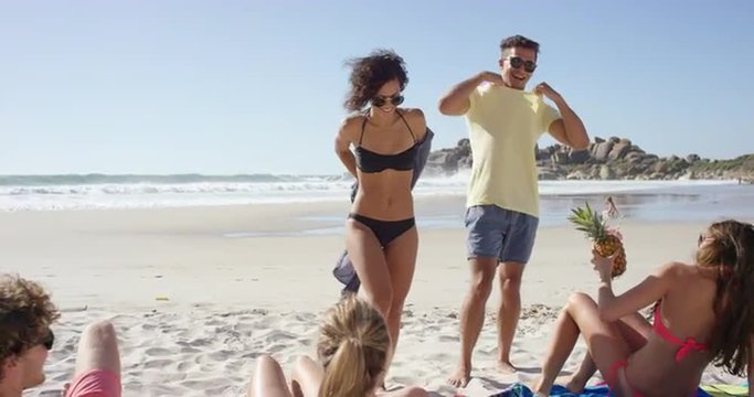 Mixed race group of friends arriving at the beach to join the party