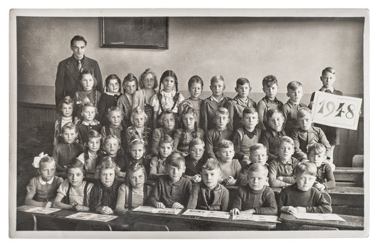 Group of children and teacher in the classroom. Retro picture