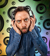 Man with headphones on speakers background