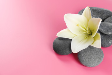 Obraz na płótnie Canvas Spa stones with flower on pink background