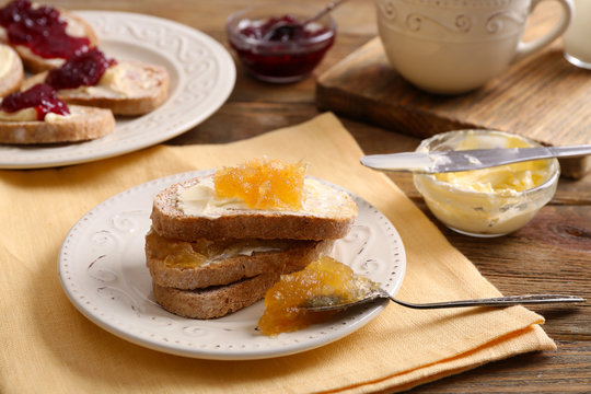 Fresh toast with butter and jam on table close up