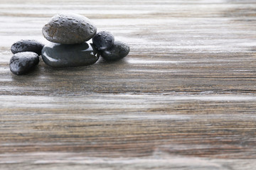 Wet spa stones on wooden background