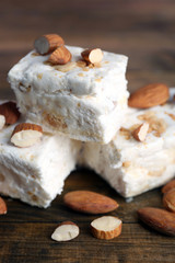 Fototapeta na wymiar Sweet nougat with almonds on wooden background