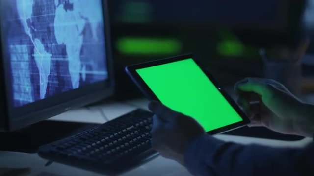 IT Professional is Using Tablet with Green Screen at Work