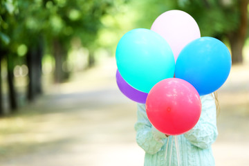 Fototapeta na wymiar Girl holding balloons near face