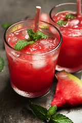 Cold watermelon drinks in glasses, on dark background