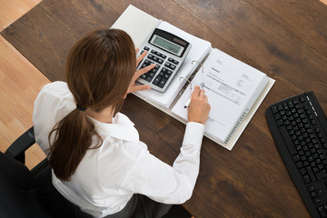 Businesswoman With Invoice And Calculator