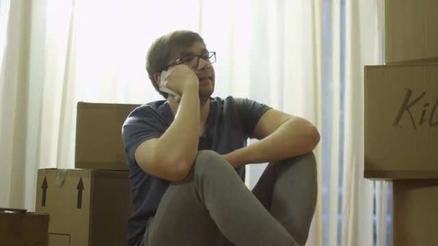 Man is Talking on Phone in New House after Moving. Shot on RED Cinema Camera in 4K (UHD).