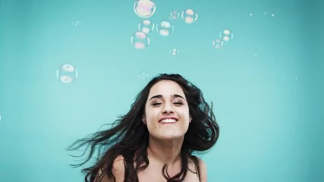 Crazy face busty Indian woman dancing in bubble shower  slow motion photo booth blue background