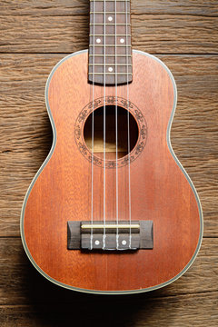Ukulele guitar on wood background