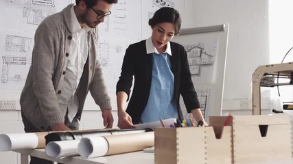 Small business team of architects discussing startup business using 3d printer