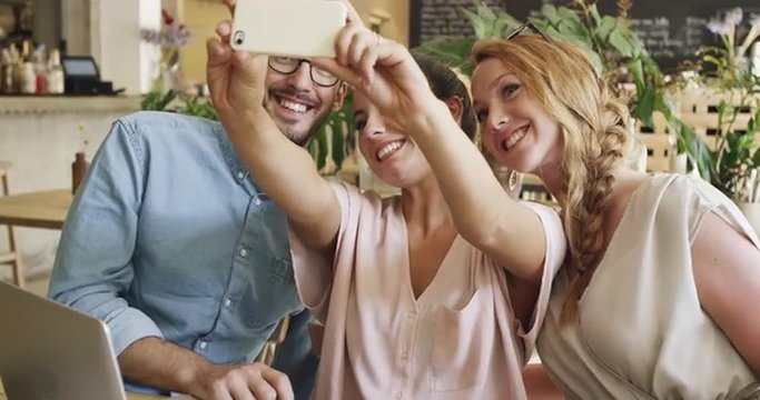 Beautiful people taking selfie in cafe mobile phone