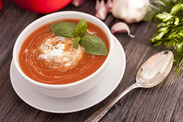 Delicious tomato soup with aromatic spices on a wooden table.