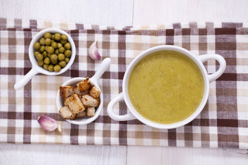 A delicious pea cream with aromatic spices on a wooden table.