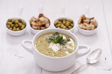 A delicious pea cream with aromatic spices on a wooden table.