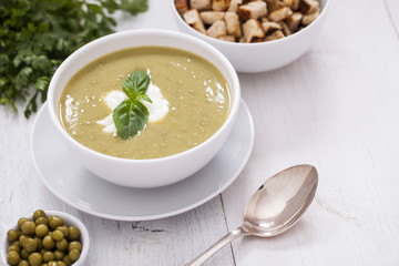A delicious pea cream with aromatic spices on a wooden table.