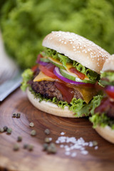 Beef burgers on a wooden board with aromatic spices