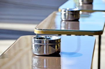 Obraz premium Edelstahl-Aschenbecher auf Stehtischen vor einem Restaurant